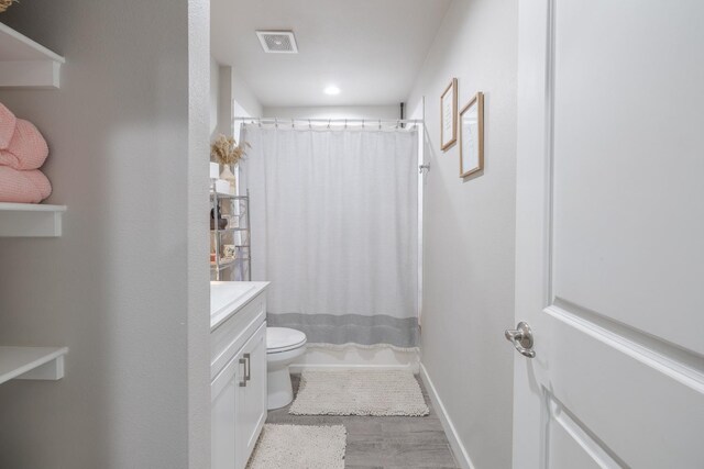 full bathroom featuring vanity, hardwood / wood-style floors, toilet, and shower / bath combo with shower curtain