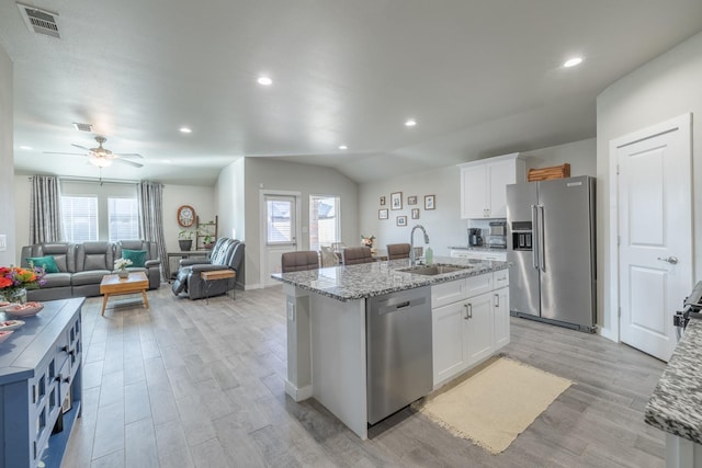 kitchen featuring appliances with stainless steel finishes, sink, a center island with sink, and white cabinets