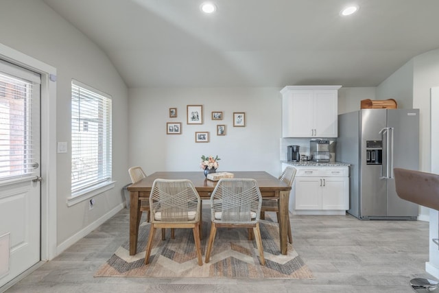 dining area with lofted ceiling and light hardwood / wood-style floors