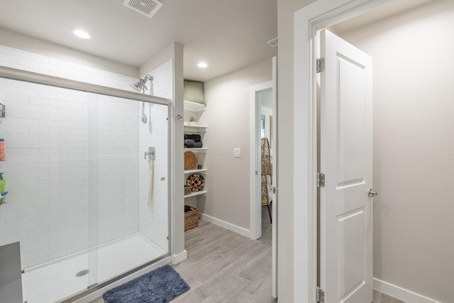 bathroom featuring wood-type flooring and an enclosed shower