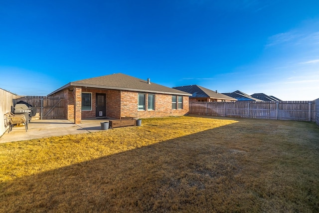 back of house with a lawn and a patio area