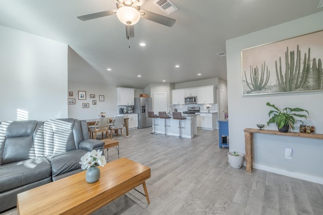 living room with ceiling fan and light wood-type flooring