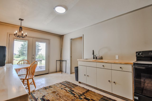 kitchen featuring sink, white cabinets, hanging light fixtures, electric range, and french doors