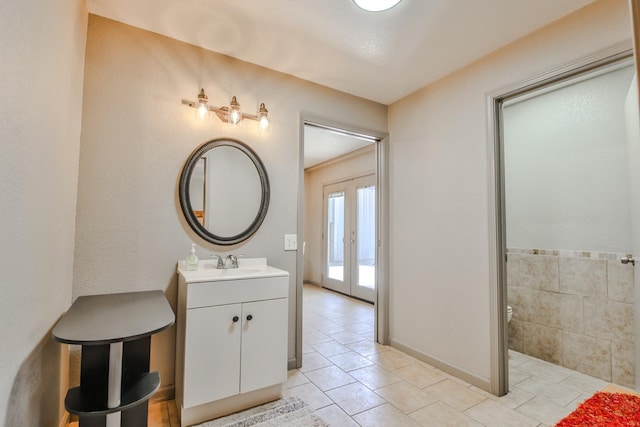 bathroom with french doors, tile patterned floors, and vanity