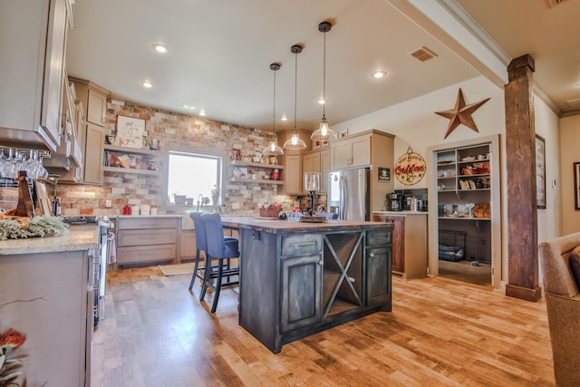 kitchen with a breakfast bar, tasteful backsplash, hanging light fixtures, a kitchen island, and stainless steel appliances