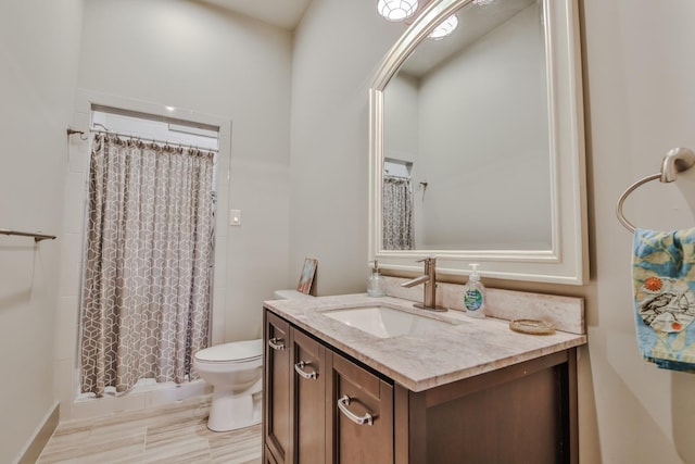 bathroom featuring vanity, toilet, and curtained shower