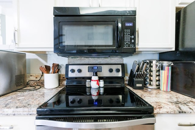 kitchen featuring stainless steel electric range oven, light stone countertops, and white cabinets