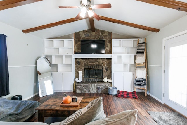 living room featuring hardwood / wood-style flooring, ceiling fan, a stone fireplace, and lofted ceiling with beams