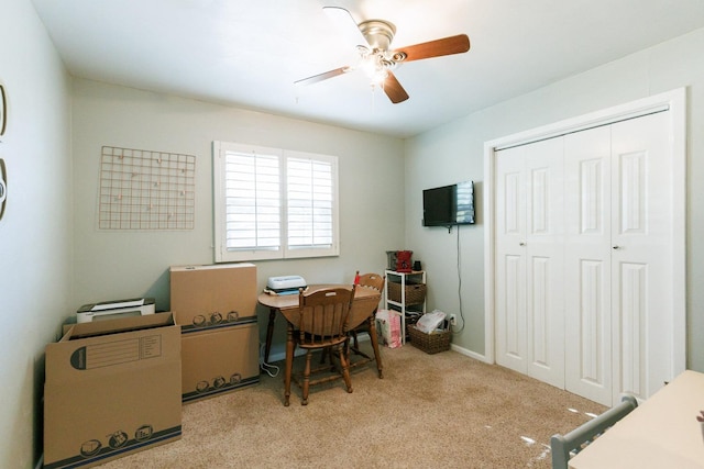 carpeted office space featuring ceiling fan