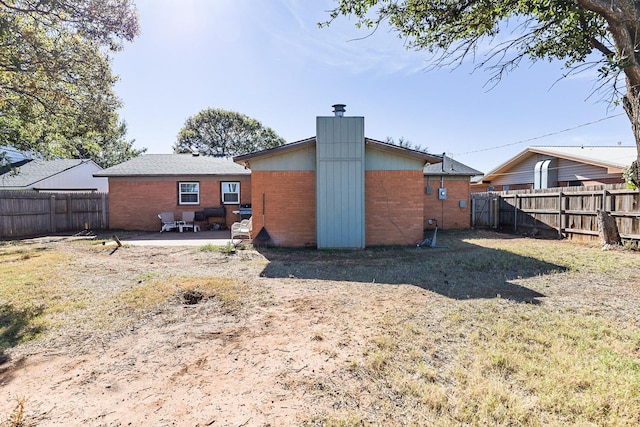 rear view of property featuring a yard and a patio area