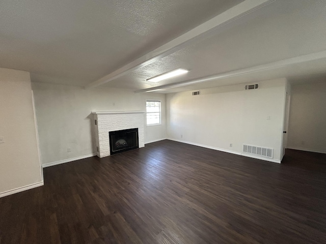 727 E 12th St, Littlefield, TX 79339 - unfurnished living room featuring dark wood-style floors, a fireplace, baseboards, and a textured ceiling