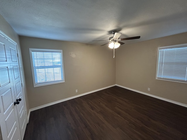 727 E 12th St, Littlefield, TX 79339 - unfurnished room with dark wood finished floors, baseboards, ceiling fan, and a textured ceiling