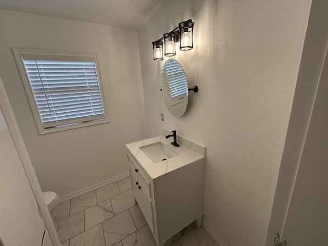 727 E 12th St, Littlefield, TX 79339 - bathroom featuring marble finish flooring, vanity, toilet, and baseboards