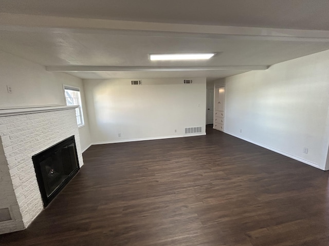 727 E 12th St, Littlefield, TX 79339 - unfurnished living room with a fireplace, dark wood-style flooring, baseboards, and beam ceiling