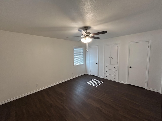 727 E 12th St, Littlefield, TX 79339 - unfurnished bedroom with dark wood-style floors, baseboards, and a ceiling fan