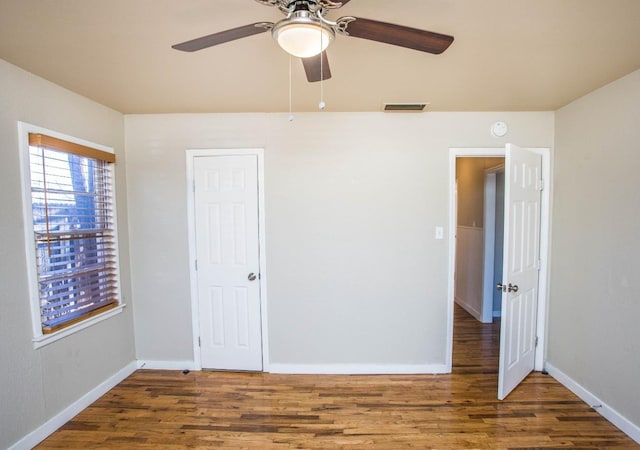 unfurnished bedroom with ceiling fan and dark hardwood / wood-style flooring