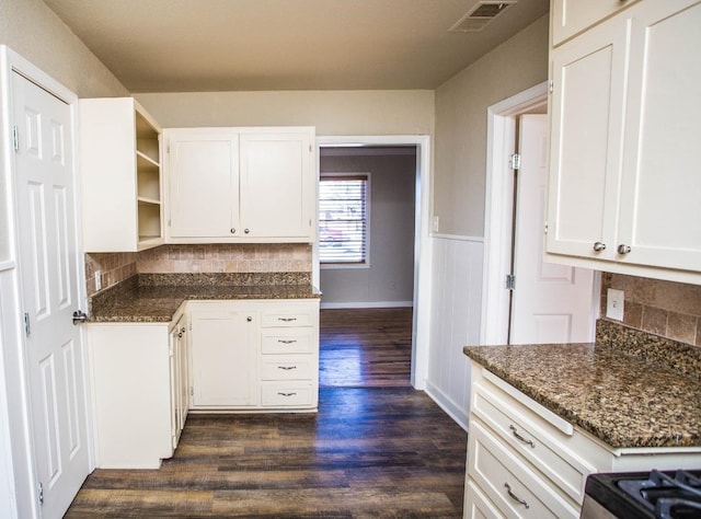 kitchen featuring dark wood-type flooring, dark stone counters, decorative backsplash, and white cabinets