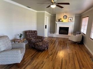 sitting room featuring crown molding, wood-type flooring, and ceiling fan