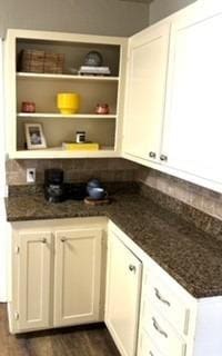 bar featuring white cabinetry, dark stone counters, and dark hardwood / wood-style floors