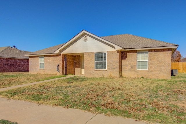 single story home with central AC unit and a front yard