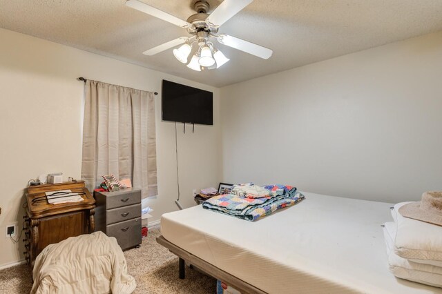 bedroom featuring ceiling fan, light colored carpet, and a textured ceiling