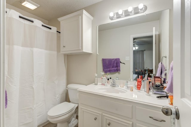 bathroom featuring vanity, a textured ceiling, and toilet