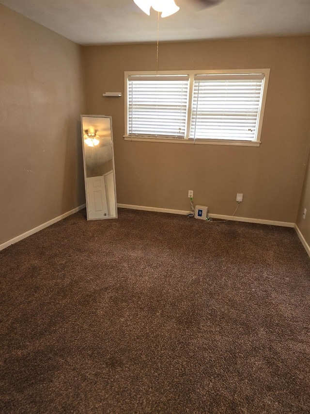 spare room featuring dark carpet