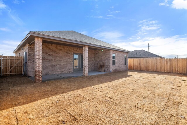 7814 96th St, Lubbock, TX 79424 - rear view of property with a fenced backyard, brick siding, and a patio area
