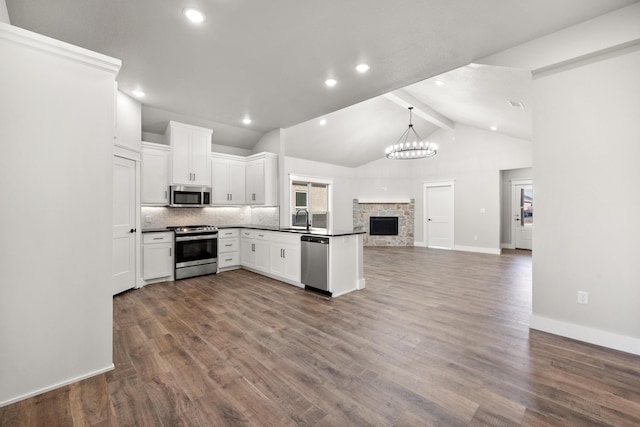 7814 96th St, Lubbock, TX 79424 - kitchen featuring appliances with stainless steel finishes, open floor plan, a sink, dark countertops, and white cabinetry