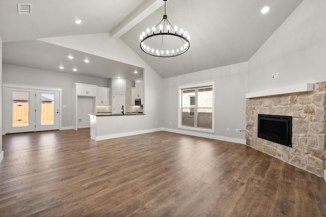 7814 96th St, Lubbock, TX 79424 - unfurnished living room with high vaulted ceiling, beam ceiling, dark wood-style floors, a chandelier, and a stone fireplace