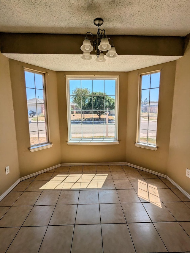 unfurnished dining area featuring a notable chandelier, tile patterned floors, and a textured ceiling