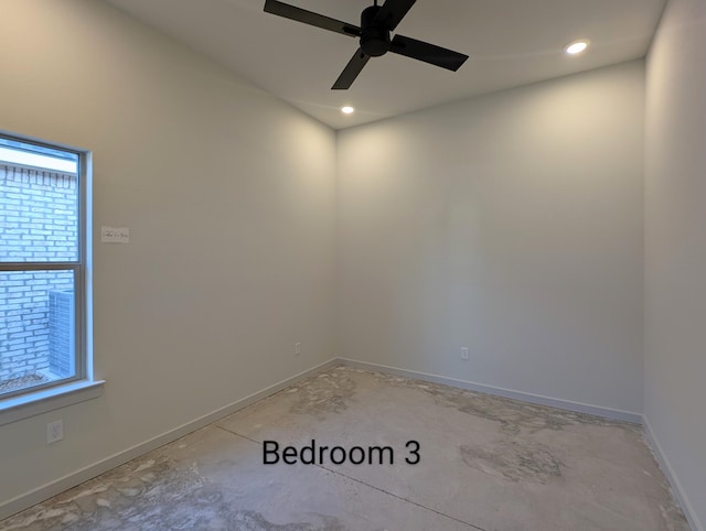 spare room featuring concrete flooring, recessed lighting, ceiling fan, and baseboards