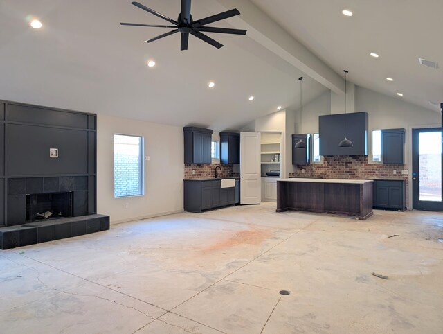 kitchen with open floor plan, light countertops, backsplash, and beam ceiling