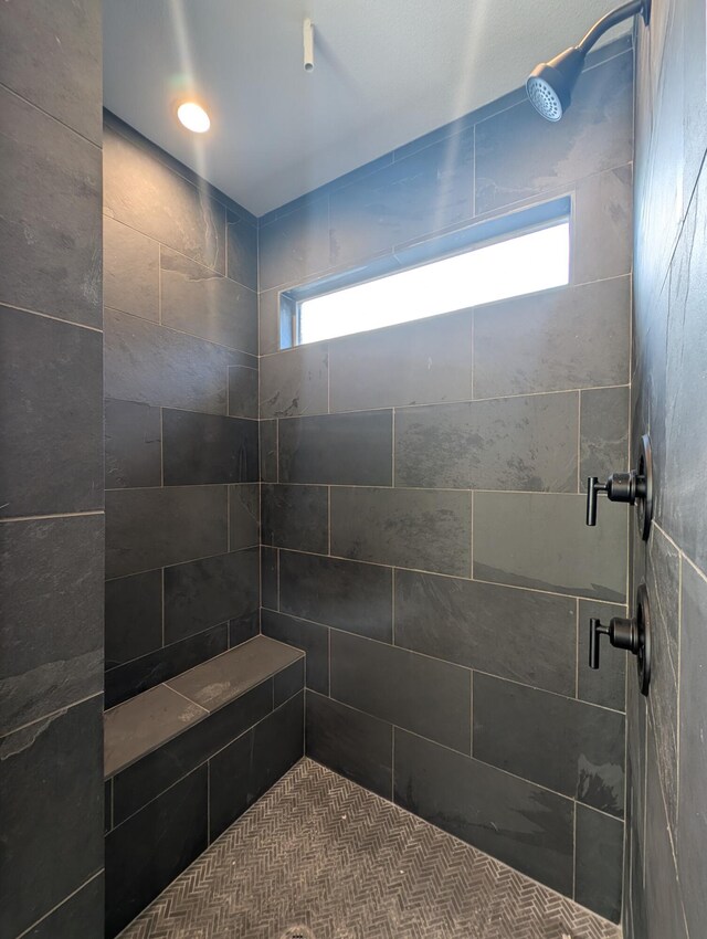 bathroom featuring tiled shower and plenty of natural light