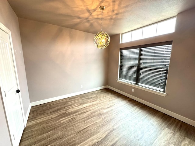 empty room with baseboards and wood finished floors