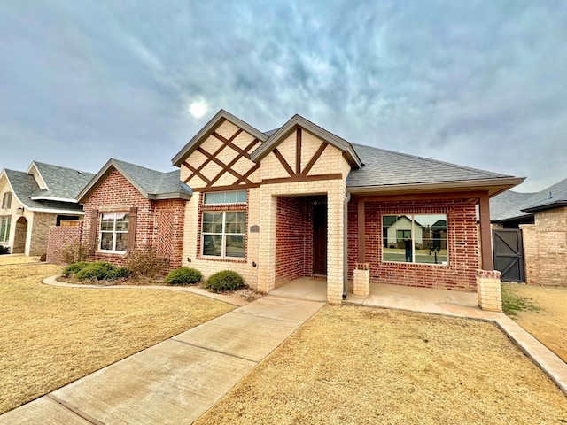 view of front of home featuring a shingled roof and brick siding