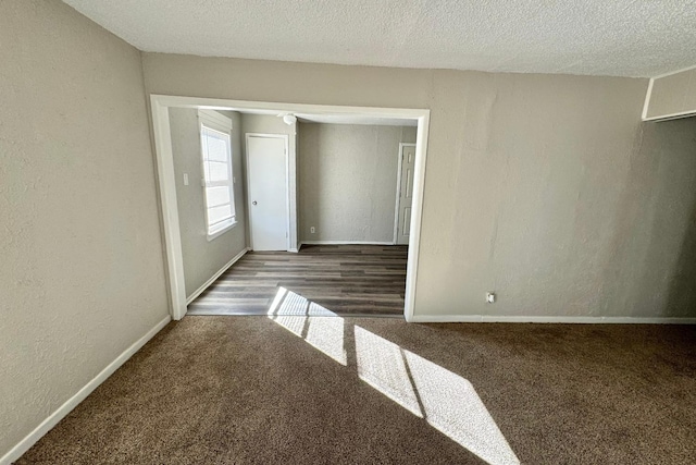 carpeted empty room featuring a textured ceiling