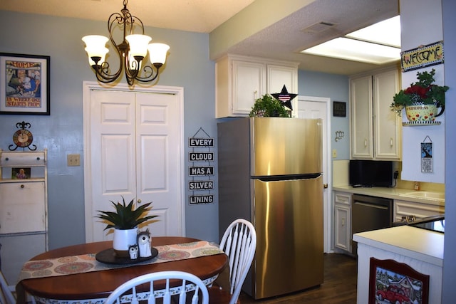 kitchen with visible vents, white cabinets, black dishwasher, light countertops, and freestanding refrigerator