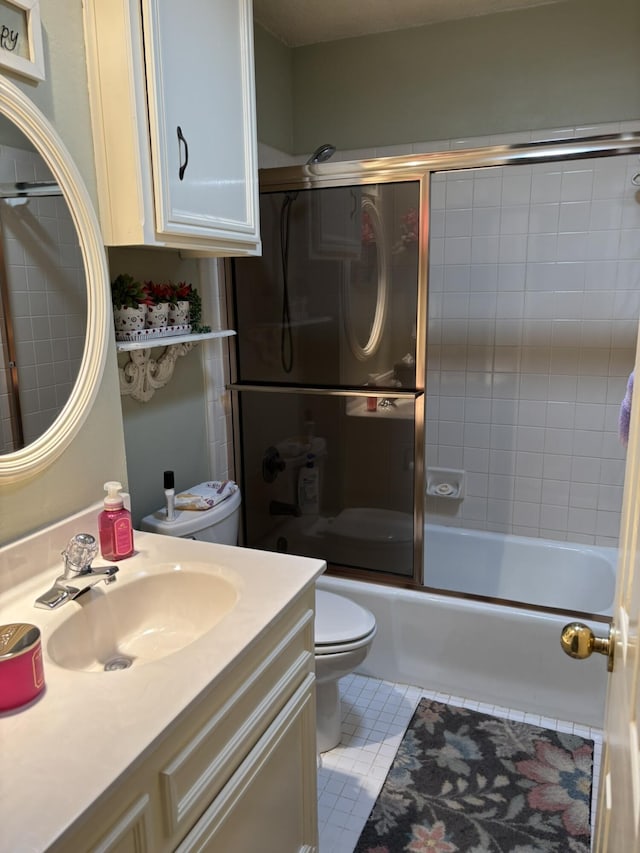 full bath featuring enclosed tub / shower combo, vanity, toilet, and tile patterned floors