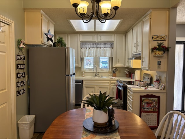 kitchen featuring electric range, freestanding refrigerator, a sink, dishwasher, and under cabinet range hood