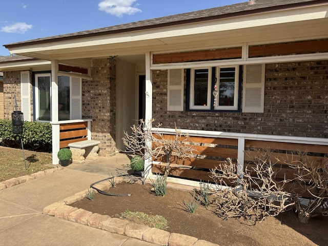 doorway to property featuring brick siding