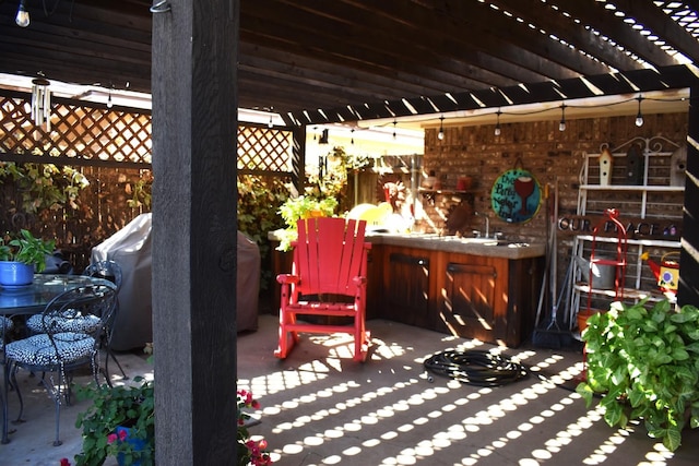 view of patio / terrace featuring a sink, a grill, and a pergola