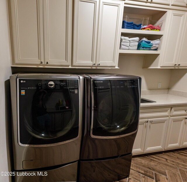 11707 Uxbridge Ave, Lubbock, TX 79424 - laundry room with cabinet space, washer and dryer, and wood finished floors