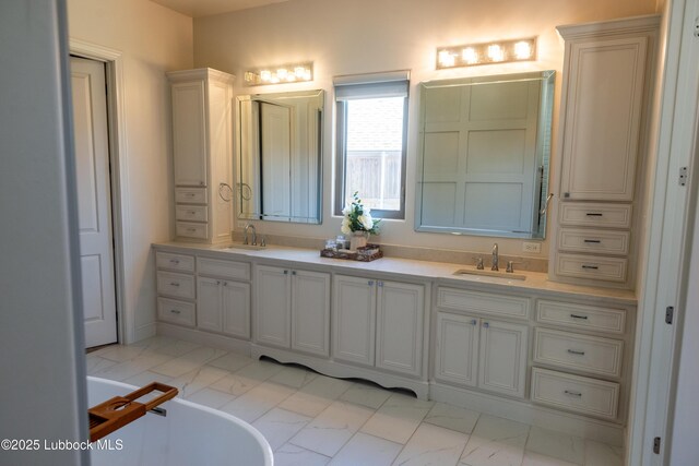 11707 Uxbridge Ave, Lubbock, TX 79424 - full bathroom with marble look tile flooring, double vanity, and a freestanding tub