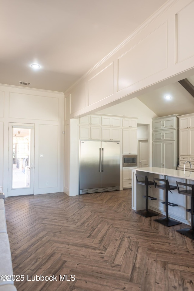 11707 Uxbridge Ave, Lubbock, TX 79424 - kitchen featuring built in appliances, a decorative wall, white cabinets, recessed lighting, and light countertops