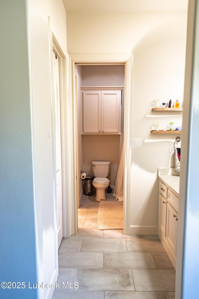 11707 Uxbridge Ave, Lubbock, TX 79424 - bathroom featuring toilet, vanity, and baseboards