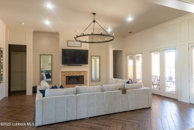 11707 Uxbridge Ave, Lubbock, TX 79424 - living room featuring a decorative wall, a chandelier, recessed lighting, a fireplace, and ornamental molding