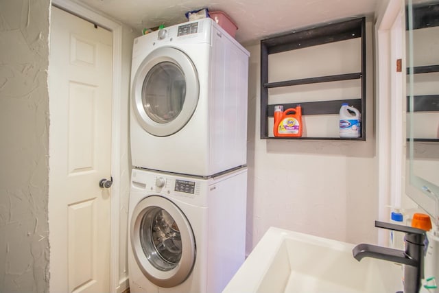 laundry room featuring laundry area, stacked washer and clothes dryer, and a sink