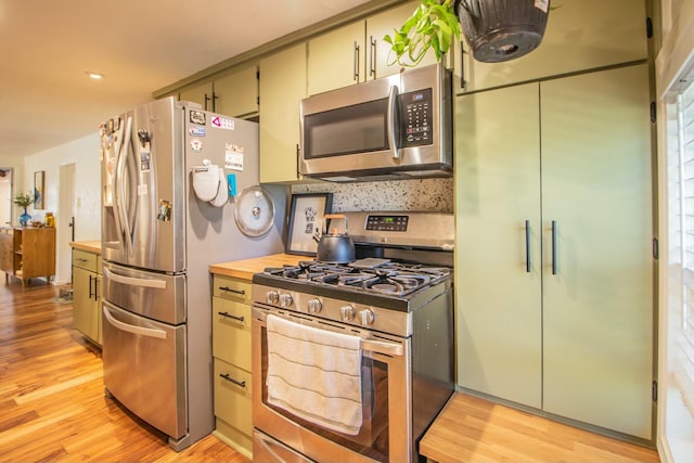 kitchen with light wood-style flooring, wooden counters, and stainless steel appliances