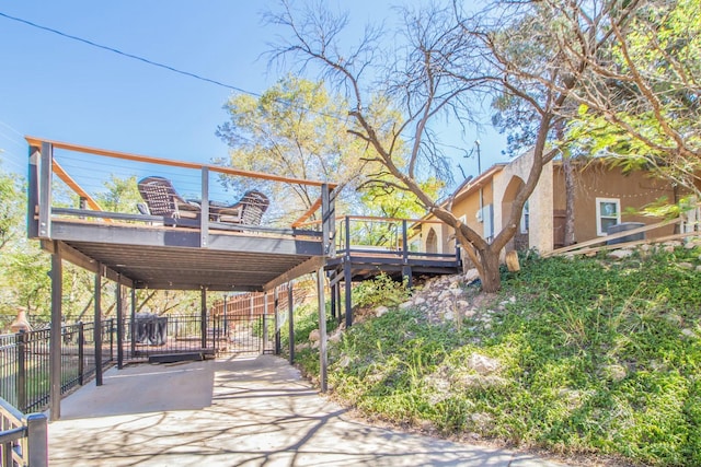 view of community featuring a detached carport, driveway, and a deck